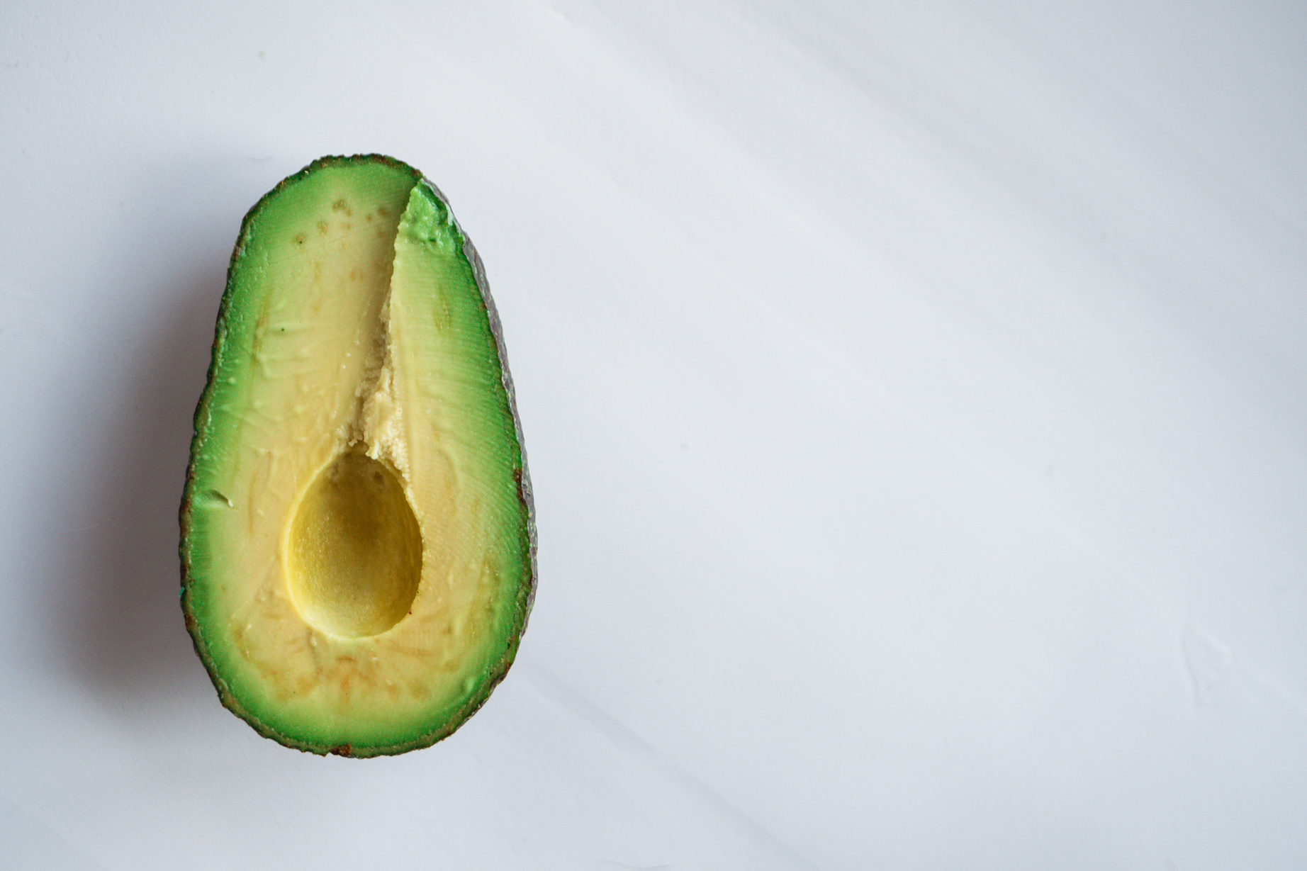 Half of ripe avocado on white background